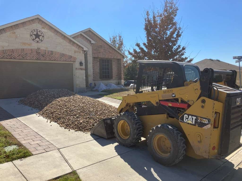 Decorative stone placement — skid steer installing river rock