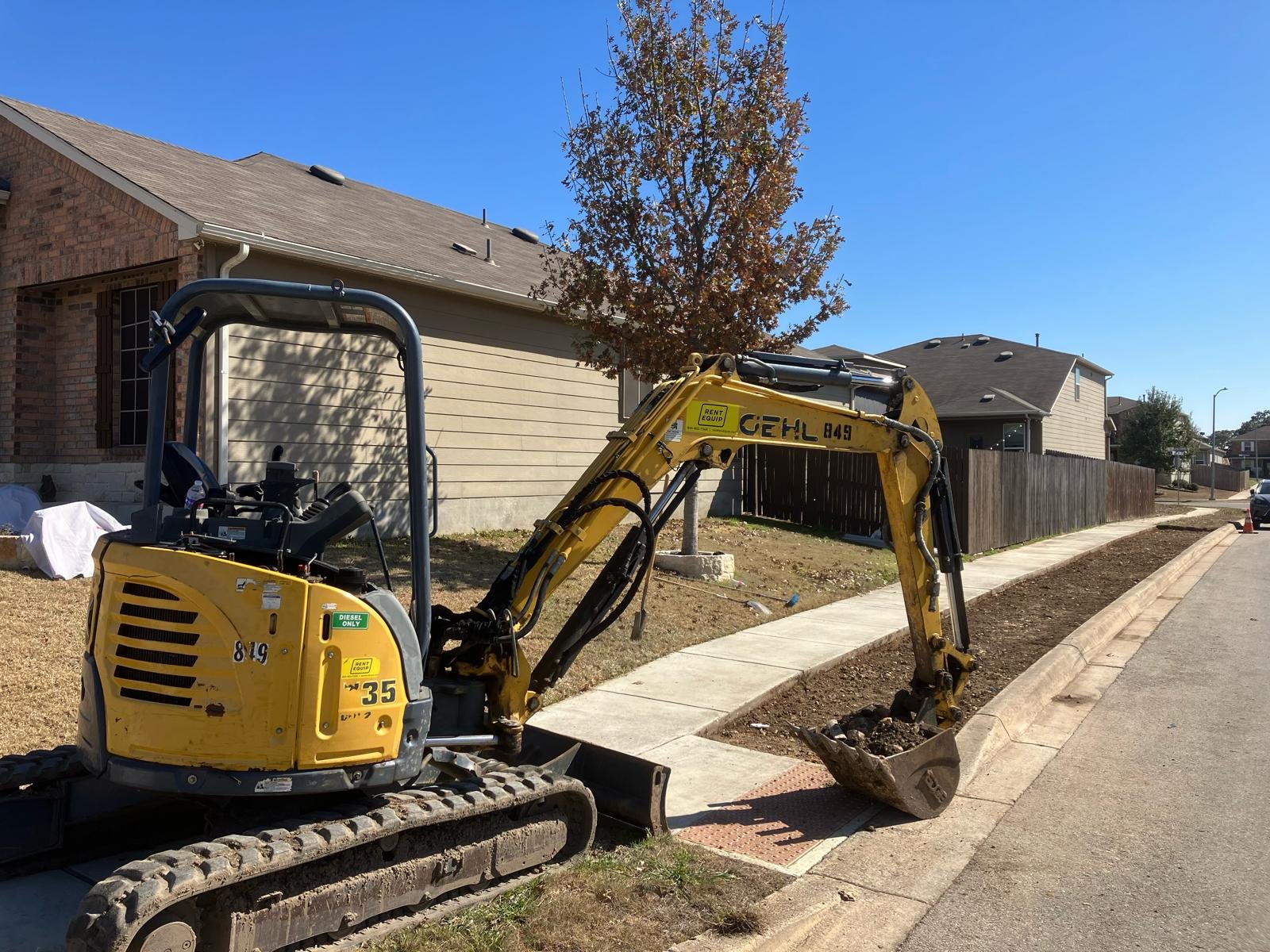 Xeriscaping in progress — excavator removing grass and topsoil